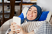 Woman on sofa using cell phone