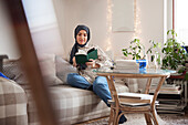 Woman reading on sofa in living room