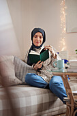 Woman reading on sofa in living room