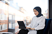 Geschäftsfrau im Hidschab benutzt digitales Tablet im Büro