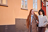 Lächelnde junge Frauen zu Fuß auf der Straße