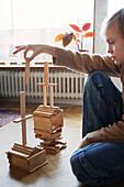 Mädchen arrangiert Turm aus Holzklötzen