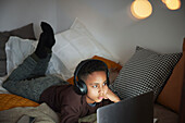 Junge macht Hausaufgaben mit Laptop in seinem Zimmer
