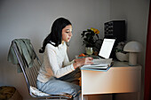 Girl doing homework with laptop