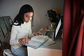 Girl doing homework with laptop