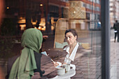 Blick durch das Fenster von Frauen im Cafe