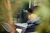 Mann mit Handy in einem Straßencafé