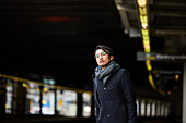 Smiling man standing at train platform