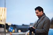 Businessman using phone outdoors in city