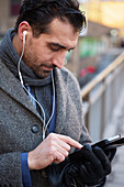 Businessman using phone outdoors in city