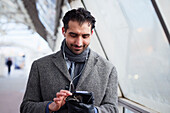 Businessman using phone outdoors in city