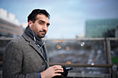 Businessman using phone outdoors in city