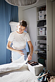 Woman folding clothes on bed