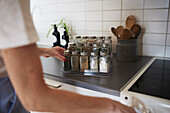 Woman's hands checking spices on spice rack