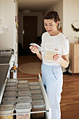 Frau prüft Kartons in Küchenschublade