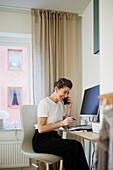 Woman at desk using cell phone