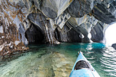 Chile, Aysen, Puerto Rio Tranquilo, Marble Chapel Natural Sanctuary. Kayaker exploring the limestone (marble) formations that has been carved and polished by the lakes wave action.