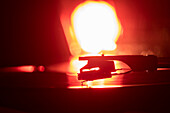 Nahaufnahme einer Plattenspielernadel auf einer Schallplatte in orangefarbenem Licht