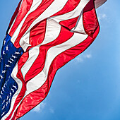Niedriger Winkel der amerikanischen Flagge weht im Wind gegen den klaren Himmel
