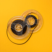 Overhead view of retro recording tape reels against yellow background