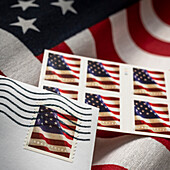Nahaufnahme von Flaggenbriefmarken und amerikanischer Flagge