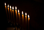 Kerzenreihe vor schwarzem Hintergrund