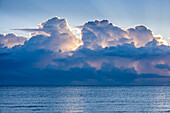 Wolken über ruhigem Meer bei Sonnenaufgang