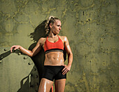Portrait of athlete woman against wall