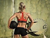 Rear view of athlete woman with medicine ball