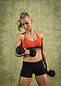 Athlete woman exercising with dumbbells