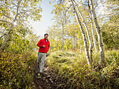 Man jogging in forest on sunny day