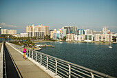 Vereinigte Staaten, Florida, Sarasota, Frau joggt auf Brücke an sonnigem Tag