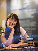 Lächelnde Frau im Cafe sitzend