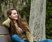Smiling woman sitting on bench in park