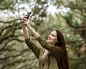 Lächelnde Frau macht Selfie im Park
