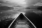 United States, New York, St. Armand, Canoe in morning mist after rain on Lake Placid, Adirondacks State Park, black and white