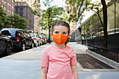 USA, New York, New York City, Portrait of girl (2-3) in face mask standing on sidewalk