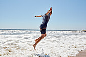 Boy (8-9) jumping in sea waves