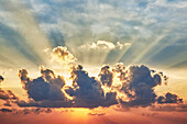 Sonnenstrahlen über Kumuluswolken bei Sonnenuntergang 