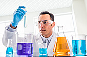Scientist looking at blue liquid in laboratory