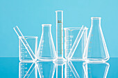 Laborgeräte aus Glas vor blauem Hintergrund