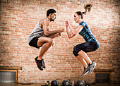 Mann und Frau springen im Fitnessstudio