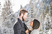 Vereinigte Staaten, Utah, American Fork, Lächelndes Paar von Angesicht zu Angesicht in einer Winterlandschaft