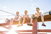 Low angle view of shirtless boys (8-9) fishing on lake