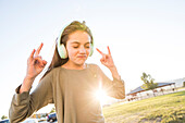 Girl (12-13) with headphones in park