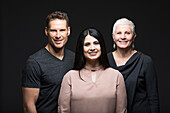 Studioporträt von drei lächelnden Menschen