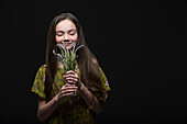 Studio portrait of smiling girl (10-11) holding bunch of grape hyacinths