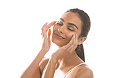 Portrait of smiling young woman doing face massage