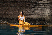 Frau sitzend auf Holzfloß in Cenote