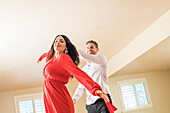 Cheerful couple dancing in apartment 